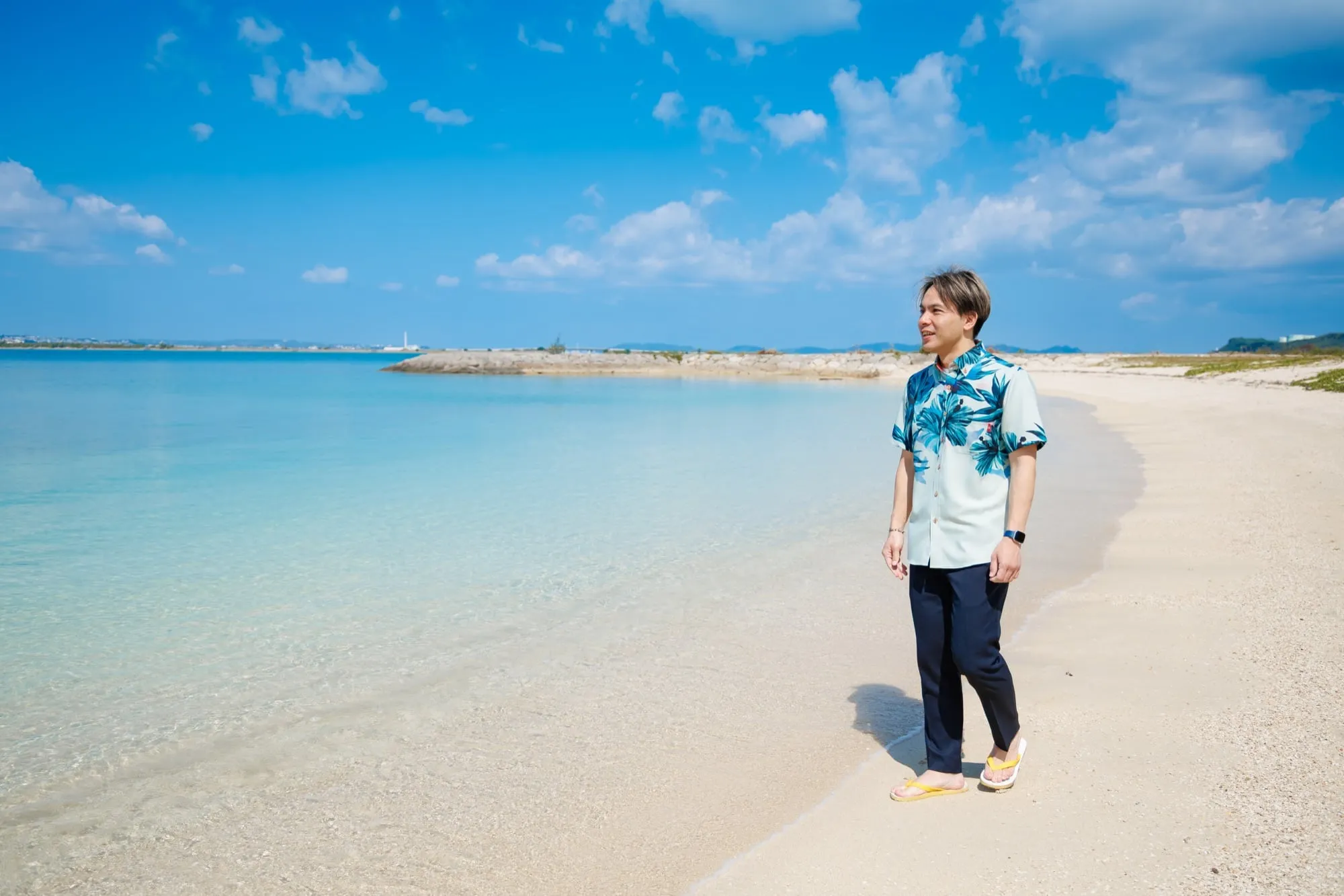 沖縄の海辺に立つ代表 高瀬昭尚